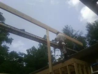 Carpenter setting a ridge beam over a new addition frame — Ice Dam Removal by Roofing Brothers in Fulks Run
