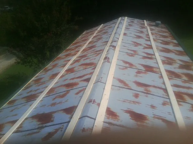Rusted metal roof panels with new wood purlins before replacement — Storm Damage Roof Repair in Fulks Run by Roofing Brothers
