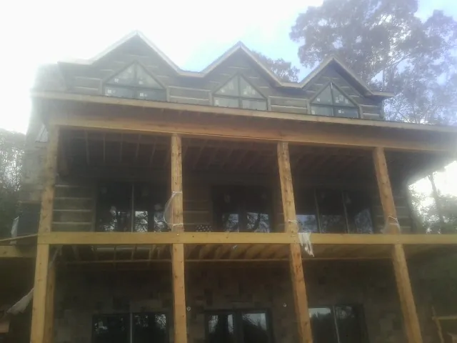 Dormers and porch framing on a large log home under construction — Roof Coating work by our crew in Fulks Run